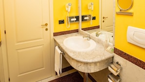 A bathroom with a white sink, mirror, and toilet. - Pushkin Hotel (Uralsk)