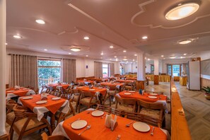 A large dining area with multiple tables, chairs, and a buffet setup.