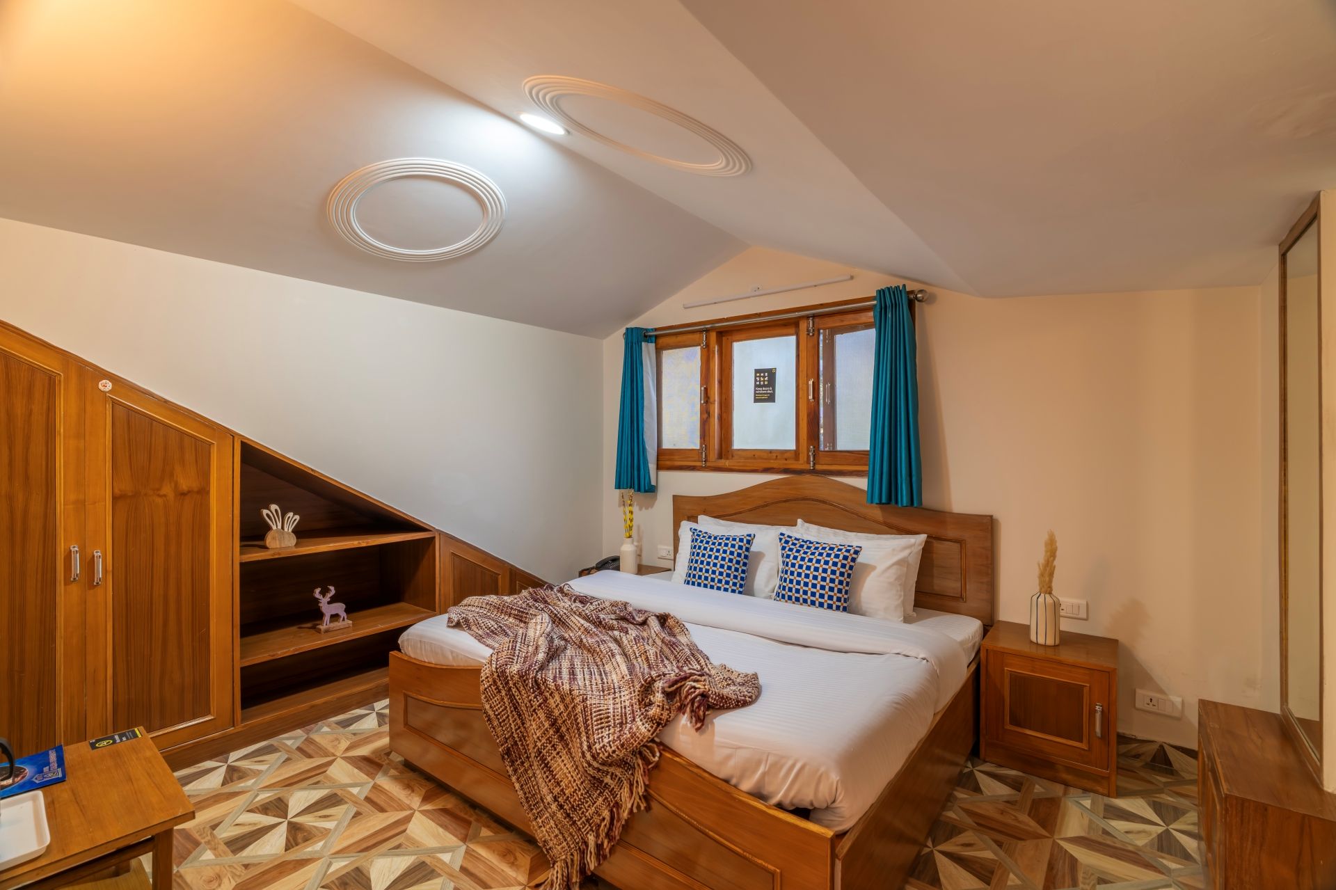 Un dormitorio con una cama de madera, una mesita de noche, un armario y una ventana con cortinas.