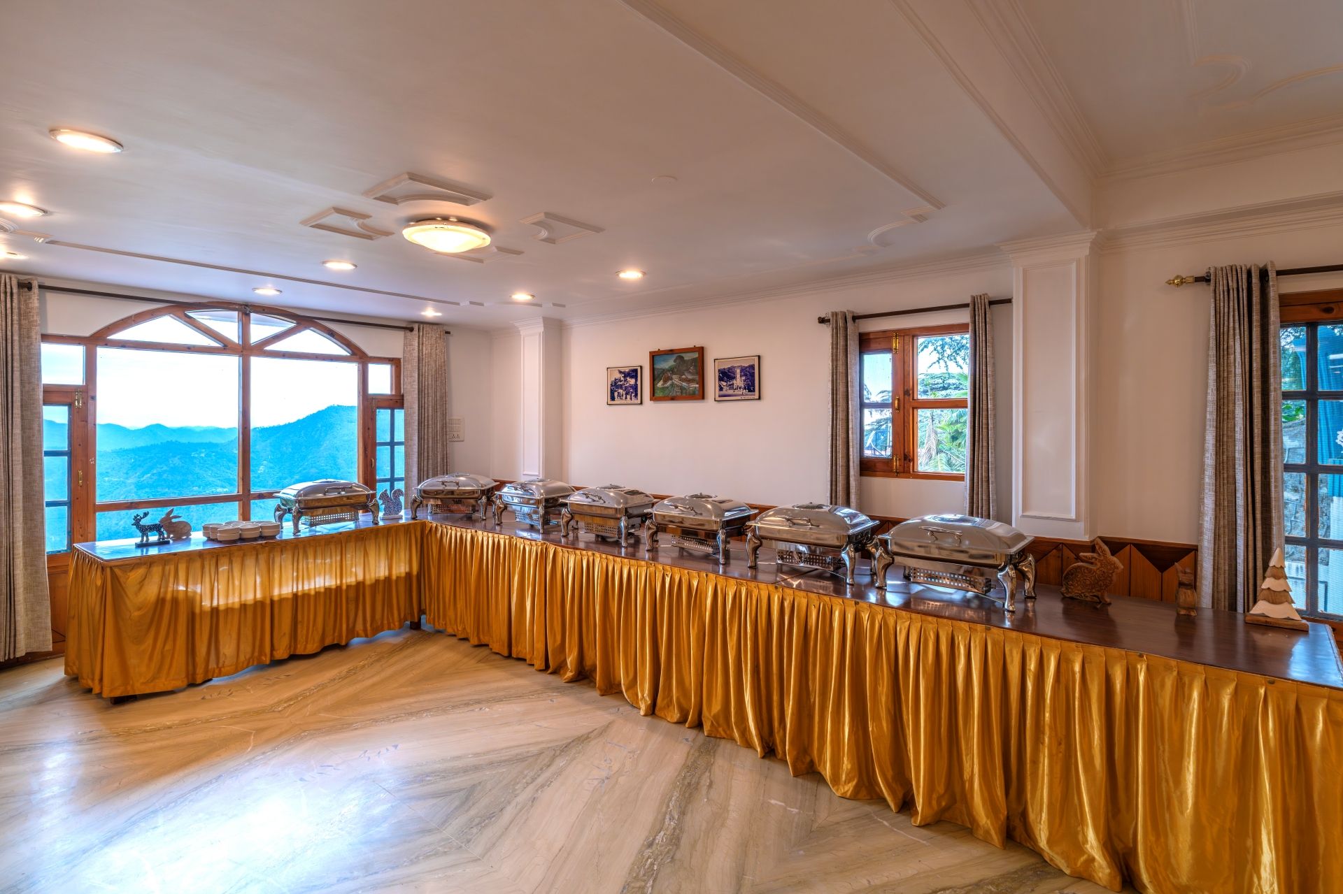 A conference room with a long table, large windows, and a view of mountains.