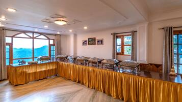 A conference room with a long table, large windows, and a view of mountains.