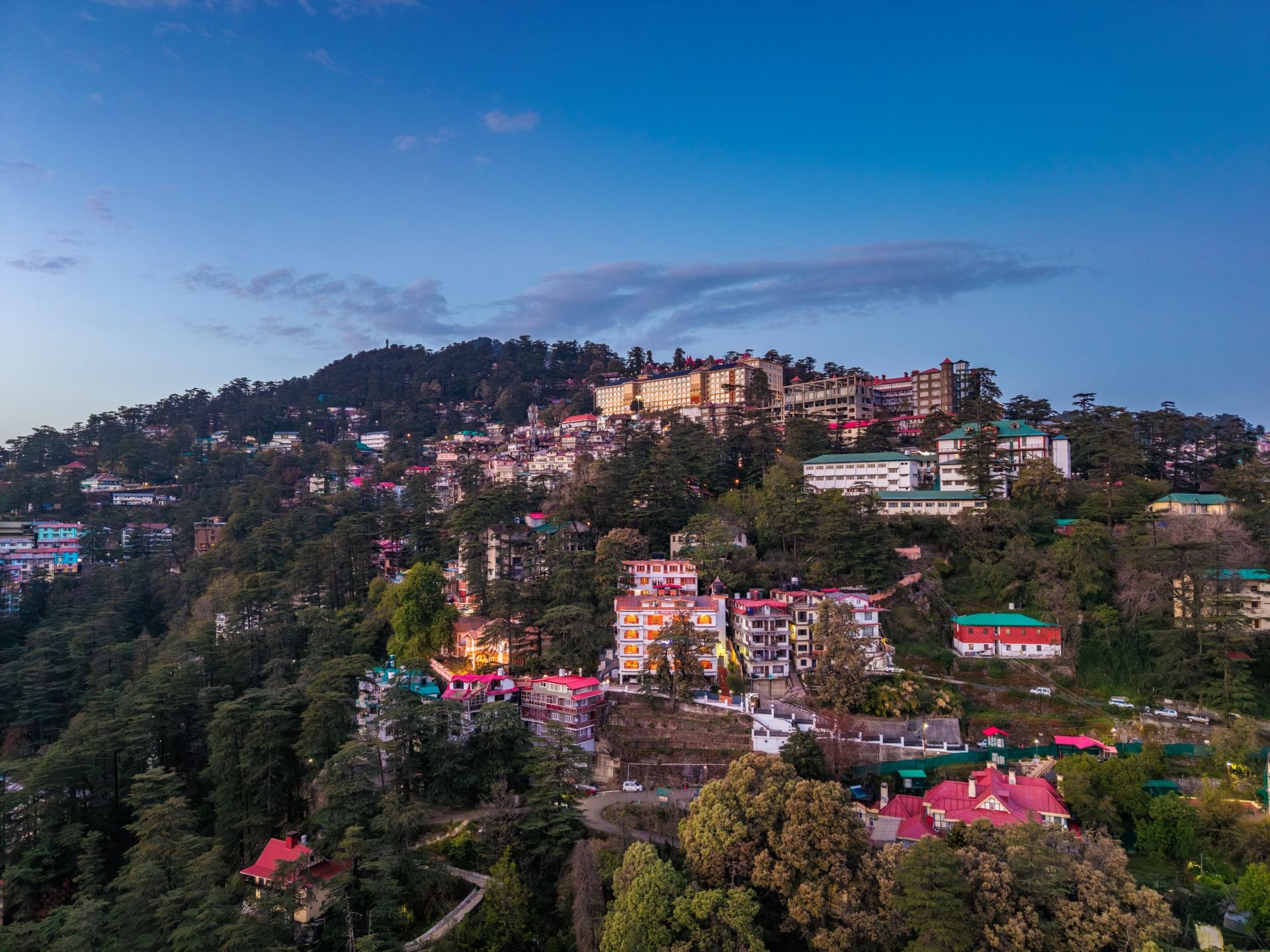 A hillside town with buildings, roads, and greenery.