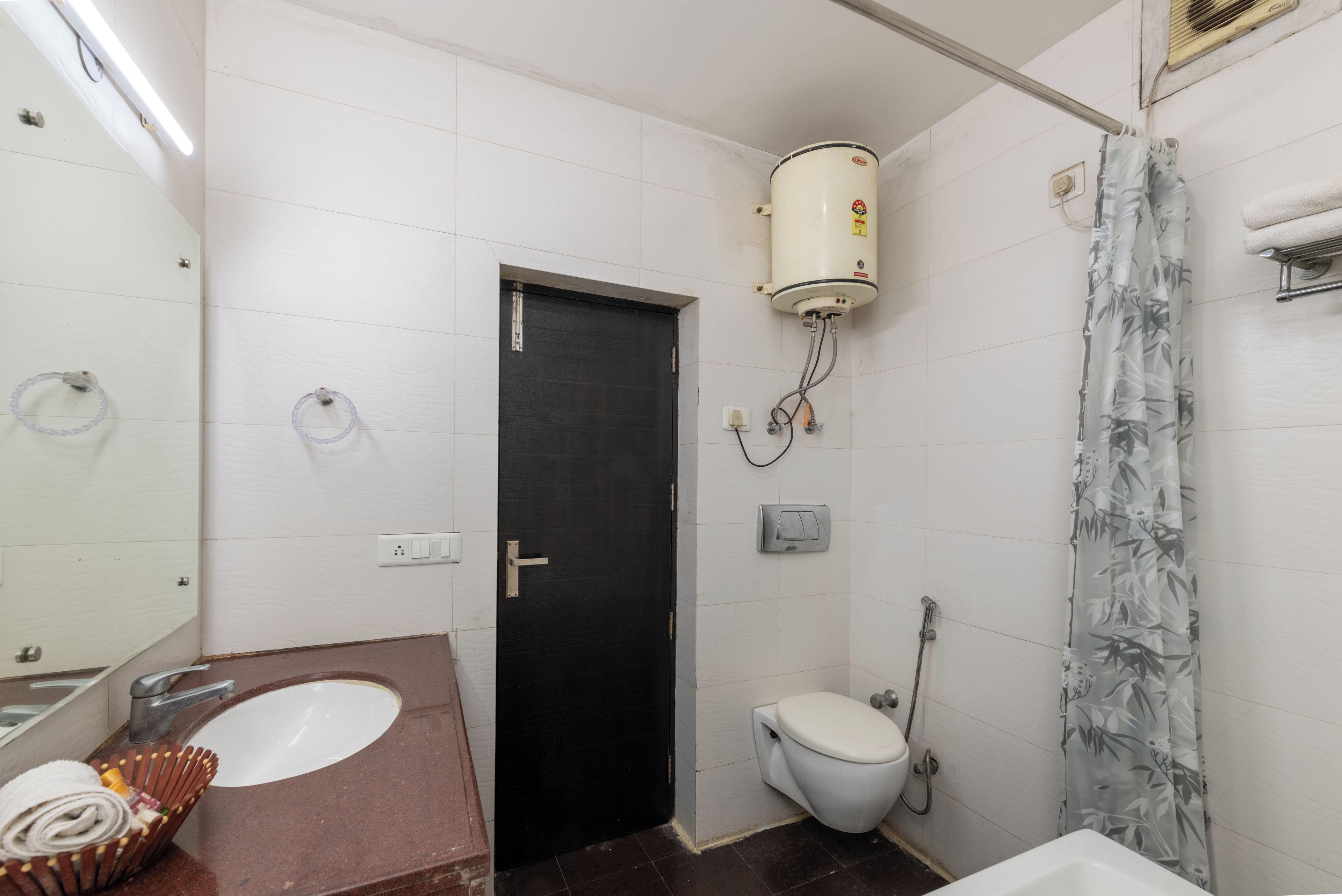 A bathroom with a white sink, a toilet, a shower, and a towel rack.