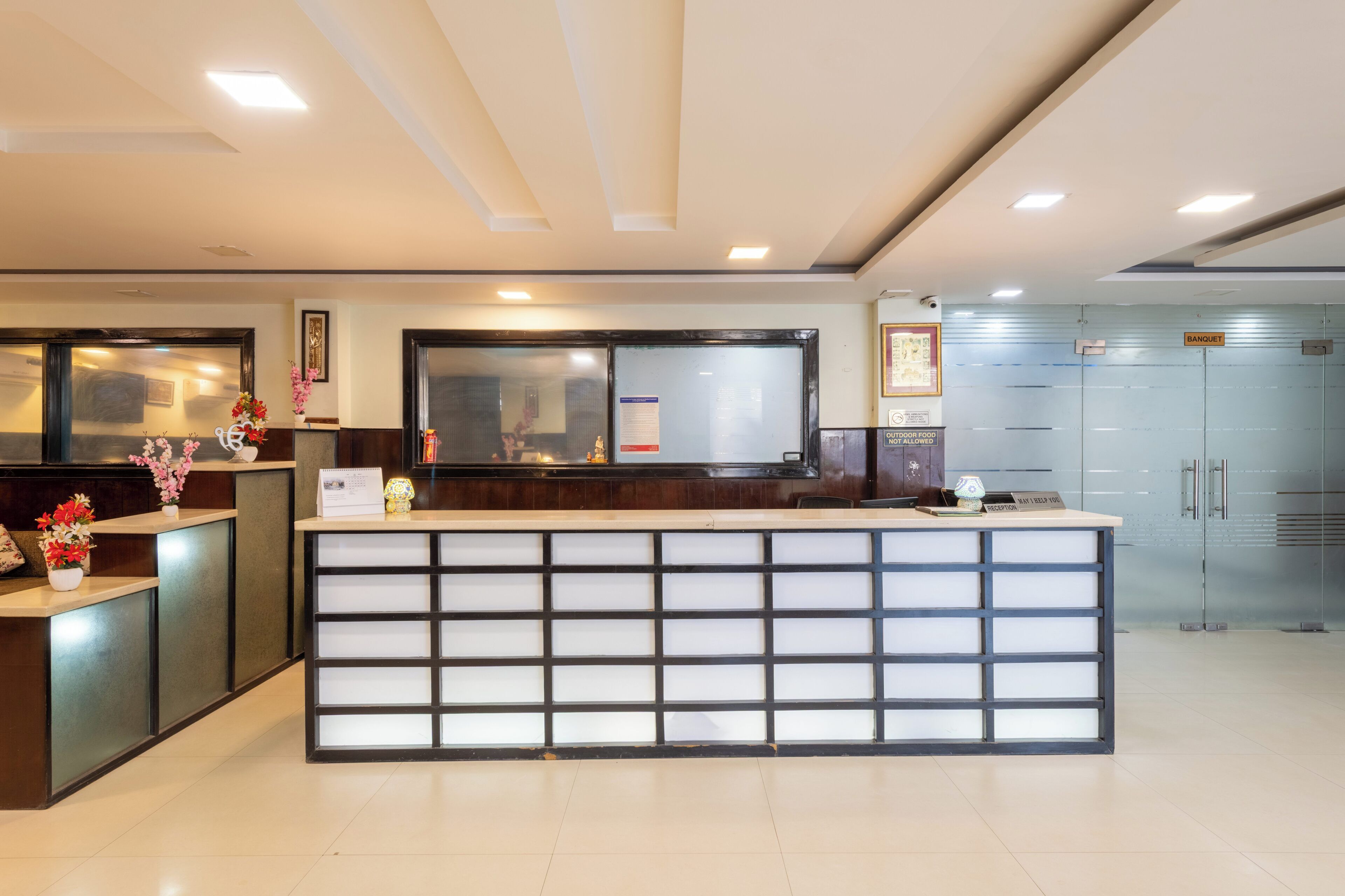 A reception area with a modern counter, a glass partition, and a visible bank.