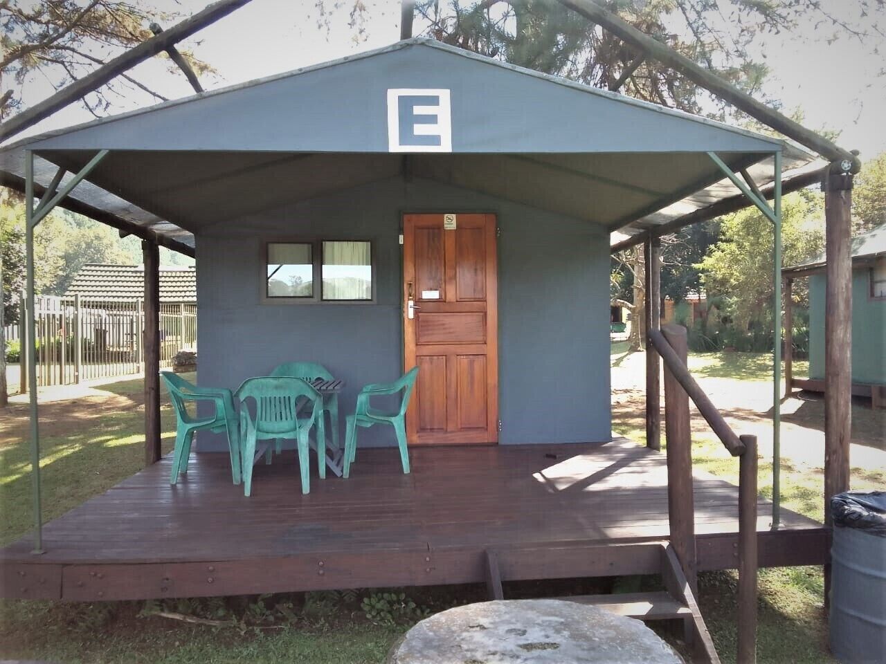 Un petit bâtiment doté d’un porche abrité, d’une porte en bois et d’une table entourée de chaises.