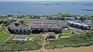 Un grand complexe hôtelier comprenant plusieurs bâtiments, un espace piscine central et une plage.