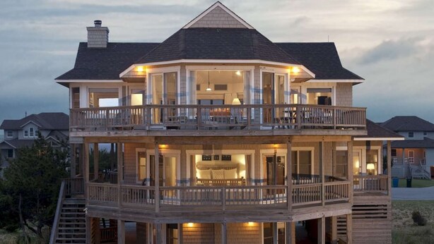 Une maison à deux étages avec un balcon, un escalier et une terrasse.