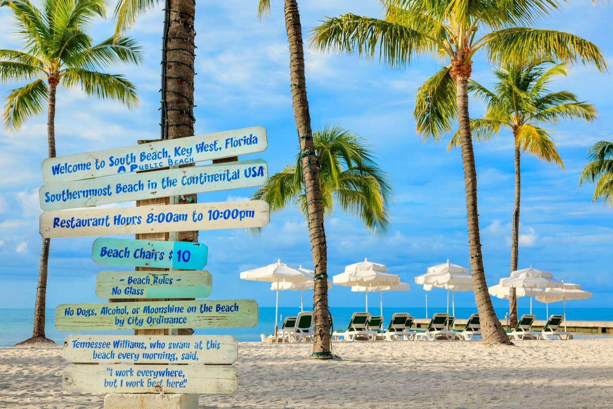 Un panneau d’information sur la plage de South Beach, à Key West, en Floride, indiquant notamment les heures d’ouverture des restaurants et les tarifs de location de chaises longues.