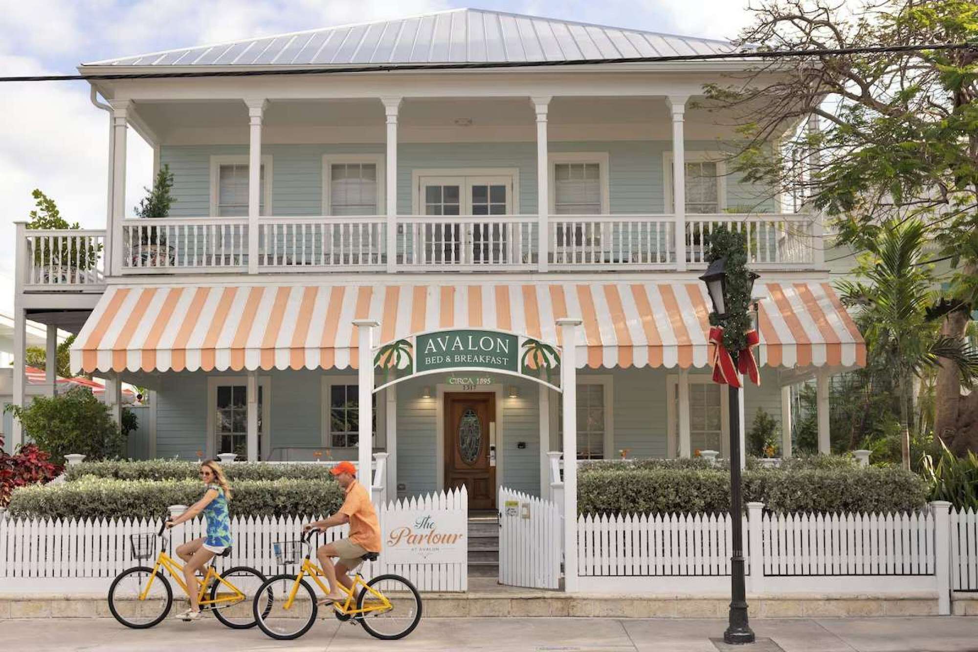 Un bâtiment à deux étages doté d’un balcon, d’une enseigne indiquant « Avalon Bed & Breakfast », et d’une clôture blanche en piquets.