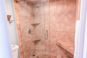 A glass-enclosed shower stall with a showerhead, a handrail, and a shelf. - 705 S Hampton Comfortable Oceanview Retreat with Private Balcony (Myrtle Beach)