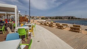 Ein Restaurant direkt am Strand mit Außenplätzen und Meerblick.