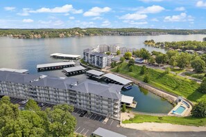A hotel with multiple buildings, a dock, and a swimming pool. - 2B 2B | Lake View | Seasonal Pool | Hot Tub |Grill (Lake Ozark)