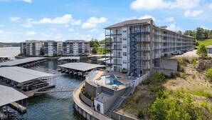 A waterfront hotel with multiple buildings, a pool area, and docked boats. - 2B 2B | Lake View | Seasonal Pool | Hot Tub |Grill (Lake Ozark)