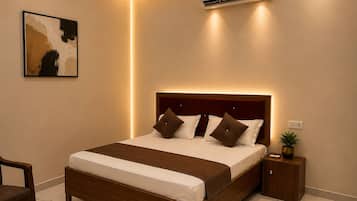 A bedroom with a bed, bedside table, and an air conditioning unit.