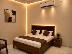 A bedroom with a bed, bedside table, and an air conditioning unit. - Sivago hotel (Chhata)