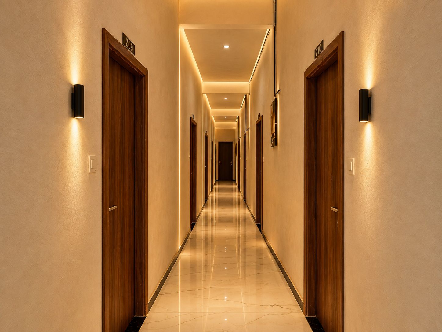 A hotel hallway with wooden doors, numbered room signs, and wall-mounted light fixtures.