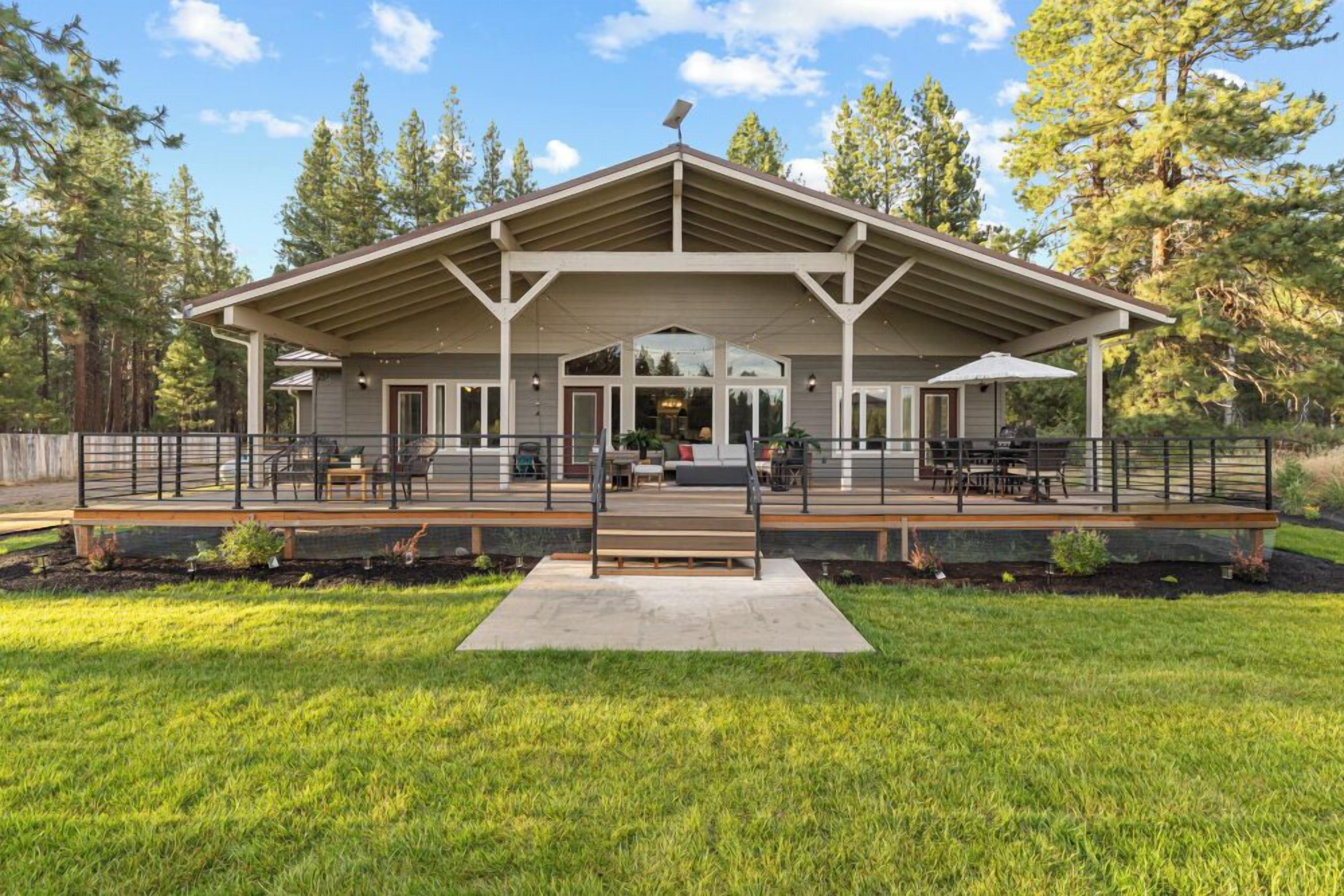 A covered outdoor seating area with a bench, tables, and chairs.