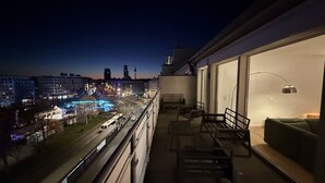 Un balcón con vista a la ciudad, un sofá y una mesa.