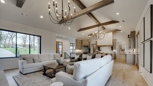 Ein geräumiges Wohnzimmer mit einer großen Couch, einem Couchtisch und einer Deckenleuchte.