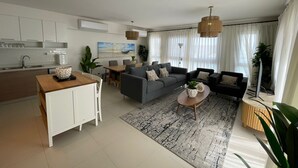 A modern living room with a sofa set, a coffee table, and a dining area. - Penthouse 4 Bedrooms Marina2-14LR-305 (El Alamein)