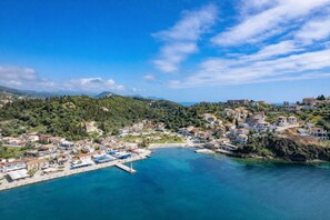 A coastal town with buildings, a pier, and a clear blue sea. - Esperides Erithia-seaside Syvota Mountain View Gem (Igoumenitsa)