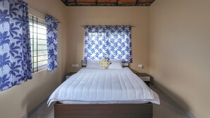 Une chambre à coucher avec un lit, des rideaux, une fen être et une table de chevet.