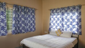 Une chambre à coucher avec un lit, des rideaux et une fenêtre.