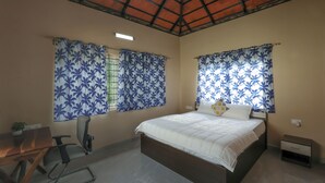 Une chambre à coucher avec un lit, un bureau, une chaise et une table de chevet.
