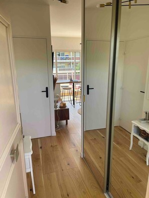Ein Zimmer mit einer Schiebetür und einem Balkon mit Tisch und Stühlen.