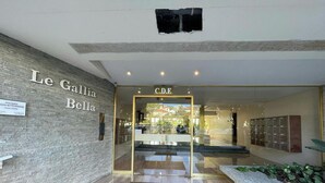 L’entrée de l’hôtel Le Gallia Bella se distingue par une porte en verre transparent, une enseigne au-dessus de la porte et un paillasson sur le sol.