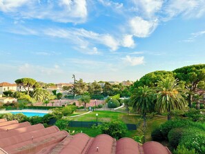 A residential area with a swimming pool, green lawns, and trees. - Vue mer 2 pièces Tennis, Piscine, plages (Antibes)