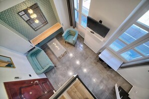 Ein modernes Interieur mit einer Couch, einem Fernseher und einer Treppe.