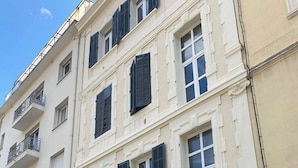 Ein mehrstöckiges Gebäude im klassischen Stil, mit symmetrisch angeordneten Fenstern und Balkonen.