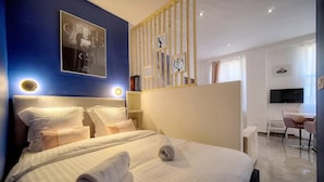 Ein Hotelzimmer mit einem großen Bett, einem Schreibtisch und einem Fernseher.