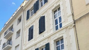 Een meerhoog gebouw met een klassieke architectuur, herkenbaar aan symmetrische ramen en balkons.
