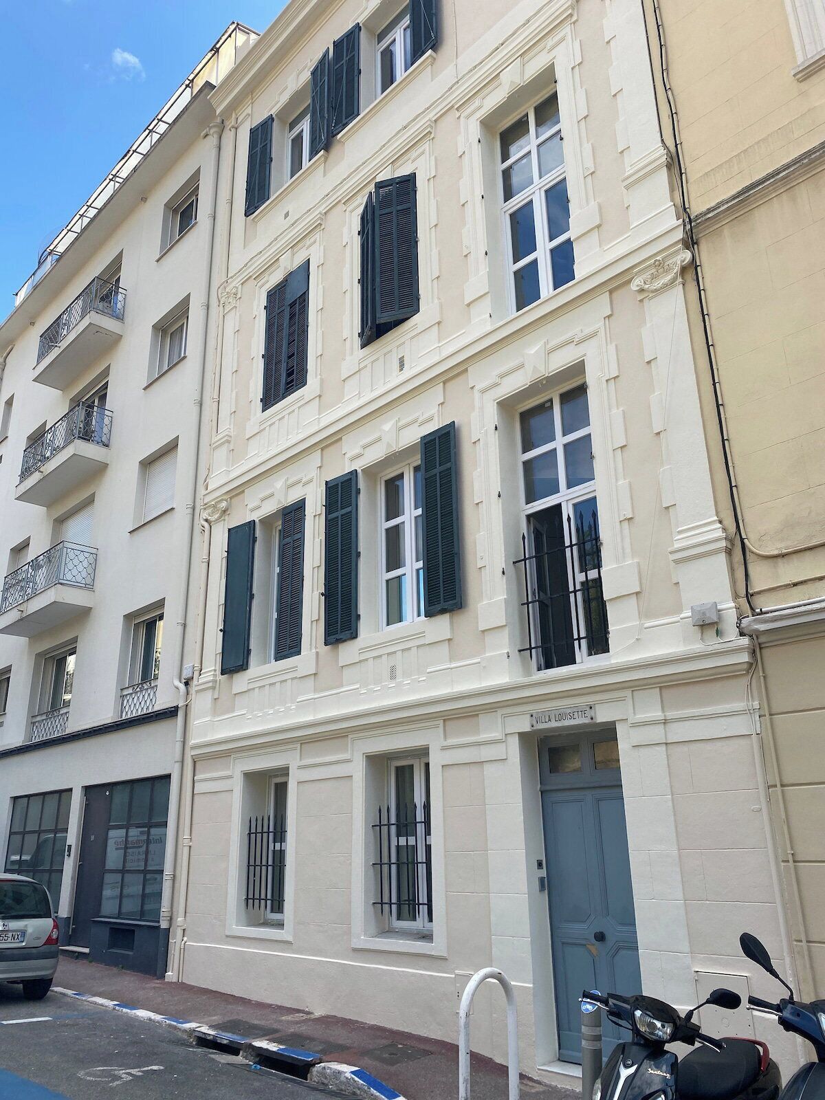 Un immeuble à plusieurs étages, de style architectural classique, doté de balcons et d’une enseigne sur laquelle on peut lire « VILLA LOUISETTE ».