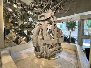 En skulpturinstallation med geometriska mönster och en reflekterande yta.