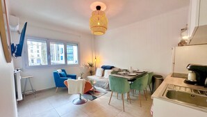 Een modern appartement met een eethoek, keuken en een groot raam.