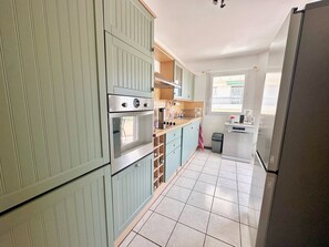 Eine Küche mit einem Doppelbackofen, einer Spülmaschine und einem Kühlschrank.