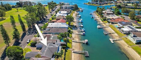 Un puerto deportivo con barcos amarrados, rodeado de edificios residenciales y vegetación.