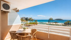 A balcony with wicker furniture, a potted plant, and a view of the beach and ocean. - Sol Wave House with Sea Views, Wi-Fi and Air Conditioning (Magaluf)