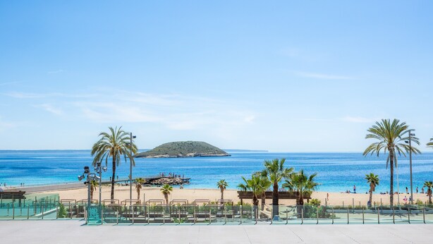 A beach view with palm trees, a clear sky, and a distant island. - Sol Wave House with Sea Views, Wi-Fi and Air Conditioning (Magaluf)