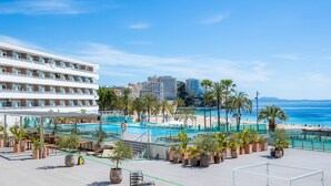 A hotel with a pool area, palm trees, and a beach view. - Sol Wave House with Sea Views, Wi-Fi and Air Conditioning (Magaluf)