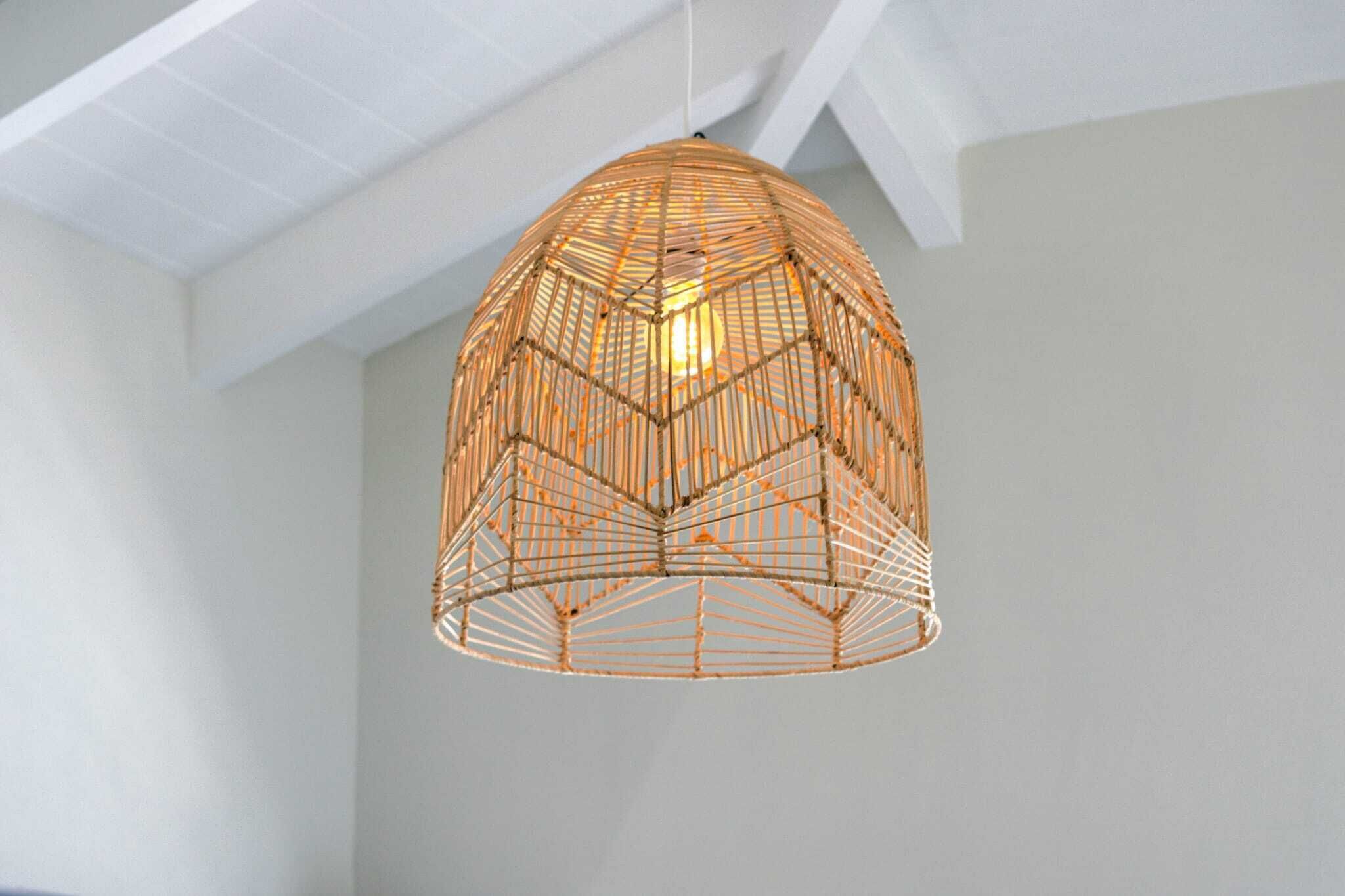 A hanging light fixture with a geometric wire design.