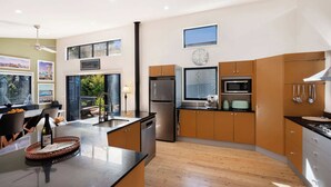Una cocina moderna con una isla central, electrodomésticos de acero inoxidable y armarios de madera.