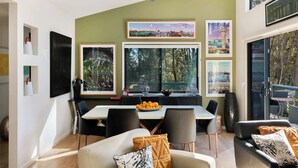Un comedor con una mesa, sillas y un tazón de fruta.