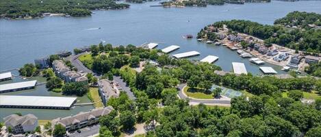 An aerial view of a waterfront property with multiple buildings, a marina, and lush greenery.