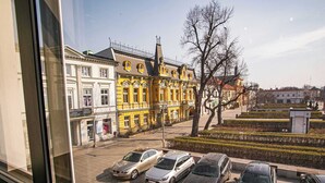 Une vue d’une rue bordée de voitures garées et d’un bâtiment à l’architecture richement décorée.