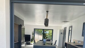 A modern kitchen with a central island, built-in appliances, and a large window providing a view of the outdoors. - Dominant house overlooking pine forest (Les Matelles)