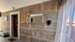 A stone wall with a door, a mirror, and a doormat. - As Casoeiras (O Grove)